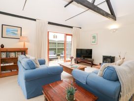 A living room with sofas, a television and a bookshelf at Willow in Wood Norton near Foulsham