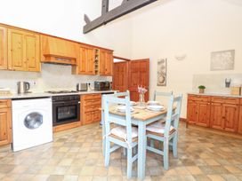 A kitchen with wooden cabinets and dining table at Willow in Wood Norton near Foulsham
