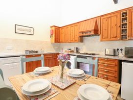 A kitchen with wooden cabinets and a table set at Willow in Wood Norton near Foulsham