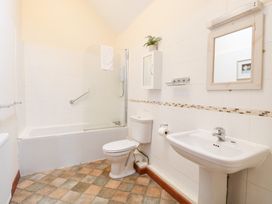 A bathroom with a bathtub, toilet, and sink at Willow in Wood Norton near Foulsham