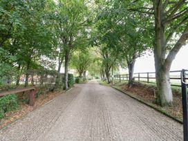 A gravel road lined with trees at Willow in Wood Norton near Foulsham