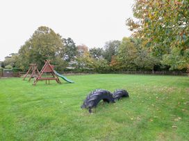 A playground with a slide and tire on grass at Willow in Wood Norton near Foulsham