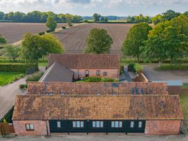 An aerial view of a house with fields and trees at Willow in Wood Norton near Foulsham
