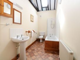 A bathroom with a sink toilet and bathtub with shower at Pear Tree in Wood Norton