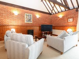 A living room with sofas and a television at Pear Tree in Wood Norton
