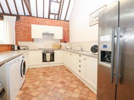 A kitchen with appliances and a window at Pear Tree in Wood Norton