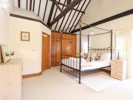 A bedroom with a four-poster bed and a dresser at Pear Tree in Wood Norton