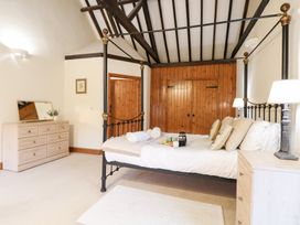 A bedroom with a king size bed and dresser at Pear Tree in Wood Norton