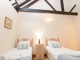 A bedroom with two single beds and a nightstand at Pear Tree in Wood Norton