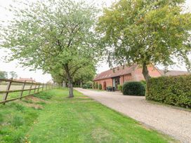 An outdoor view with trees and a gravel path at Pear Tree in Wood Norton