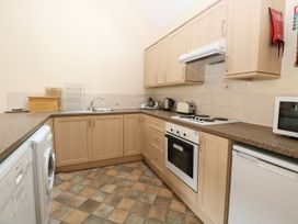 A kitchen with wooden cabinets a washing machine oven stove microwave and toaster at Holly Berry in Wood Norton near Foulsham