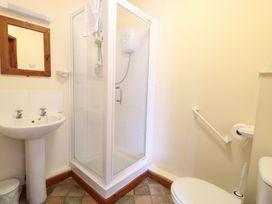 A bathroom with a shower cubicle a sink mirror and toilet at Holly Berry Wood Norton near Foulsham
