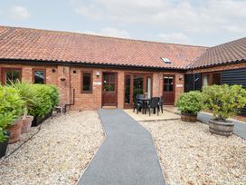 An exterior view of a property with a dining area and pathway at Holly Berry in Wood Norton near Foulsham