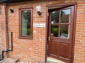 An entrance with a wooden door and a window at Holly Berry in Wood Norton near Foulsham