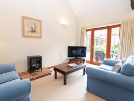 A living room with a sofa and television at Holly Berry Wood Norton near Foulsham