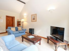 A living room with a television and sofa at Holly Berry in Wood Norton near Foulsham