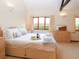 A bedroom with a bed and dresser at Holly Berry in Wood Norton near Foulsham