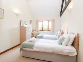 A bedroom with two beds and a dresser at Holly Berry in Wood Norton near Foulsham