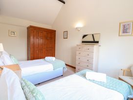 A bedroom with two beds and a wardrobe at Holly Berry in Wood Norton near Foulsham