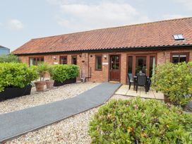 An outdoor view of the Holly Berry property with a pathway and seating area at Holly Berry Wood Norton near Foulsham