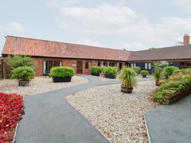 An outdoor area with a gravel path and potted plants at Holly Berry in Wood Norton near Foulsham