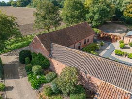 A garden with landscaping and a building at Holly Berry in Wood Norton near Foulsham