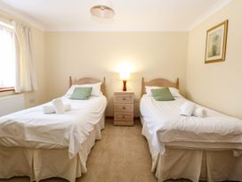 A bedroom with two single beds a nightstand with a lamp between them and a framed picture on the wall at Sycamore Wood Norton near Foulsham