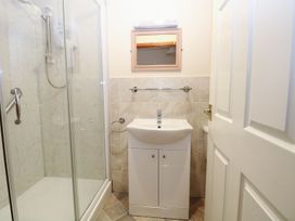 A bathroom with a shower enclosure a white sink cabinet a mirror and a towel rack at Sycamore Wood Norton near Foulsham