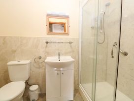 A bathroom with a toilet sink mirror and a glass shower at Sycamore Wood Norton near Foulsham