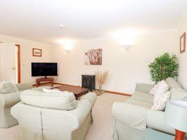 A living room with a tv and a table at Sycamore Wood Norton near Foulsham