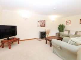 A living room with a television and sofa at Sycamore in Wood Norton near Foulsham