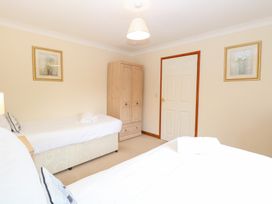 A bedroom with two beds and a wardrobe at Sycamore in Wood Norton near Foulsham