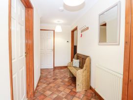 A hallway with a bench and coat hooks at Sycamore in Wood Norton near Foulsham