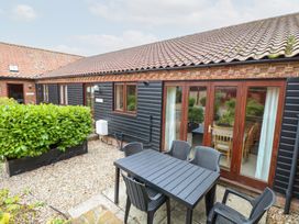 An outdoor seating area with a table and chairs at Sycamore in Wood Norton near Foulsham