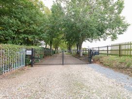 A gated driveway with trees on either side at Sycamore Wood Norton near Foulsham