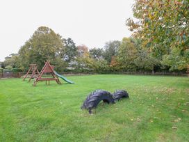 An outdoor area with playground equipment and a tire at Sycamore Wood Norton near Foulsham