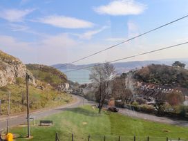 A hillside view with a road tram tracks and houses near the coastline at 4 Bay View Terrace in Llandudno