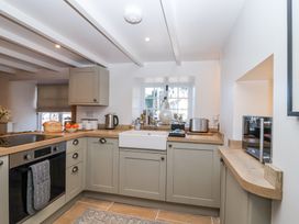 A kitchen with cabinets oven microwave sink and kitchen appliances at Harbour View in Polperro