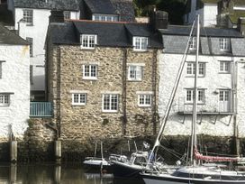 Houses by the marina with boats in the water at Harbour View Polperro