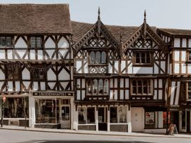 A street view of traditional timber-framed buildings with shopfronts including Bodenhams on Broad Street