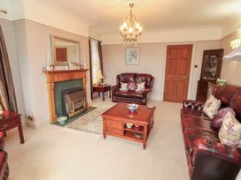 A living room with a fireplace and seating area at High Cross in Keswick