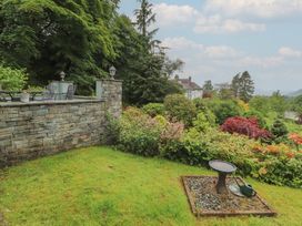 A garden with a stone wall and seating at High Cross in Keswick