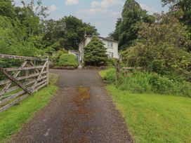 A driveway leading to a house with trees and a gate at High Cross in Keswick