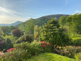 A garden with flowers and trees in view of the mountains at High Cross in Keswick