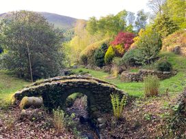 A garden with a stone bridge and various plants at High Cross in Keswick