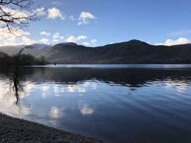 A lake with mountains and trees at High Cross in Keswick