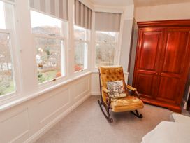 A bedroom with a rocking chair and wardrobe at High Cross in Keswick