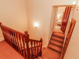 A staircase with a handrail and door leading to a bedroom at High Cross in Keswick