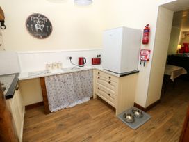 A kitchen with a refrigerator, kettle, and sink at Dolcoed Manordeilo near Llangadog
