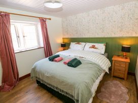 A bedroom with a bed, bedside table and lamp at Dolcoed in Manordeilo near Llangadog